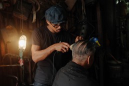 barber clipping older man's hair